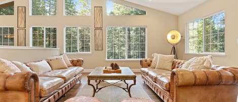 Over-spaced living room with leather couches and modern Moroccan ottomans