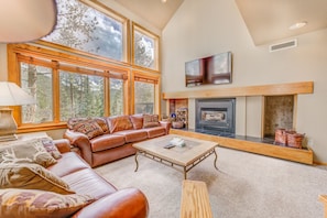 Spacious living are with vaulted ceilings, massive windows allowing for great light, gas fireplace, ample seating and a mounted flat screen TV.