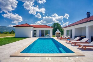 Six sunbeds next to the pool area 