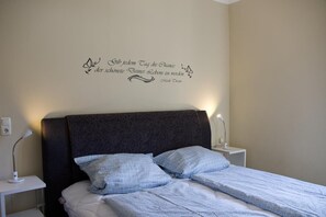 Doppelbett mit Schriftzug an der Wand der Ferienwohnung auf Fehmarn