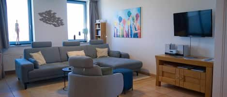 Wohnzimmer mit Couch und Sessel in der Ferienwohnung in der Strandburg auf Fehmarn