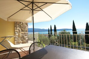 Balkon mit Seeblick, Liegestühlen und Sitzplatz