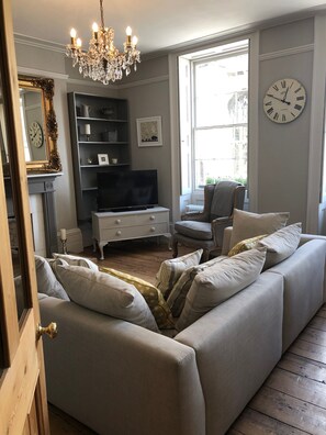 The chandelier and gilt edged mirror add a little bit of luxury to this room