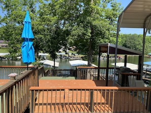 Large deck area with multiple sitting areas over looking dock and the lake. 