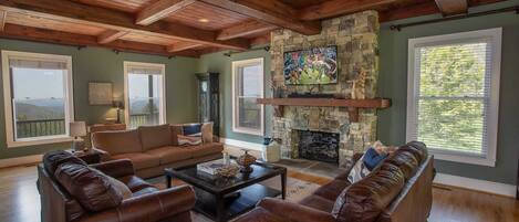 Living Room at The Retreat with Huge View Windows, Stone Fireplace, and HD Smart TV