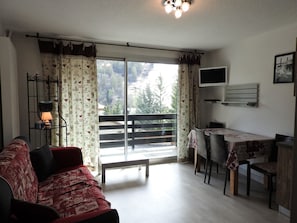 Living room with double sofa RAPIDO (140cm x 200cm) and dining area, access to the balcony facing SOUTH