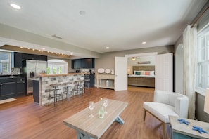 Open concept kitchen with bar stools and sitting area.