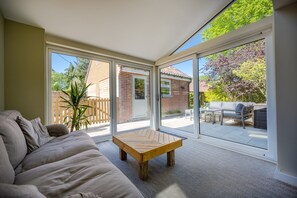 Heathcot, Holt: Sitting room with doors onto the terrace and outdoor entertainment area