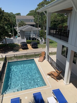 Pool deck view from bedroom 6.  Covered porch w/ rockers over looks pool 