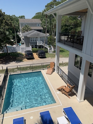 Pool deck view from bedroom 6.  Covered porch w/ rockers over looks pool 