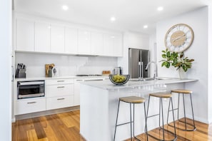 Modern kitchen. Gas cooktop, oven, microwave, fridge, dishwasher, coffee, tea