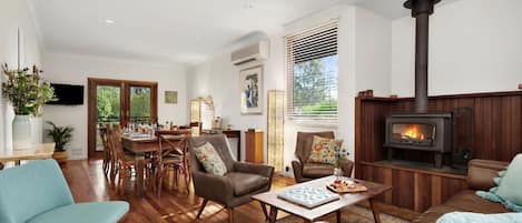 Cozy living room and dining room with indoor fireplace and aircon