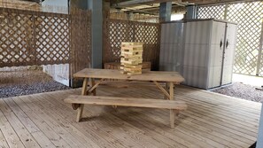 Downstairs picnic area, shed with beach accessories underneath house. 
