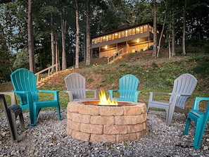 Windows in the sunroom overlook the lake, fire pit, and gorgeous mountain views.