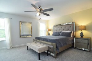 Stylish primary king suite with Smart TV, ceiling fan, large en suite bathroom