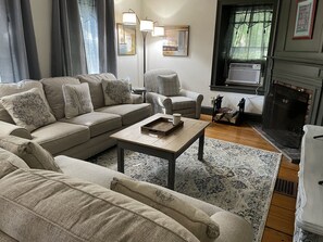 Living room (front of the home) on the main floor with wood burning fireplace.