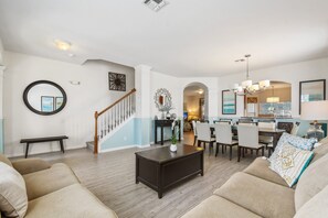 Coastal-style open living and dining area with elegant décor and seating for ten.