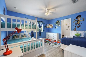 Fun Toy Story-themed kids' room with bunk beds, twin bed, and playful wall art.