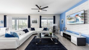 Modern living room with sleek decor, plush seating, and poolside views.