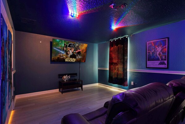 Epic Star Wars-themed home theater with mood lighting and cozy recliners.
