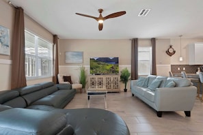 Stylish open-concept living room with modern seating and natural sunlight.
