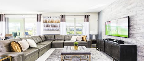 Generously sized living room featuring a cozy sofa, creating the ideal setting for a family reunion.