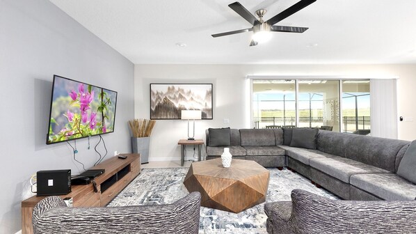 Living room with spacious couches and a large flat screen TV.