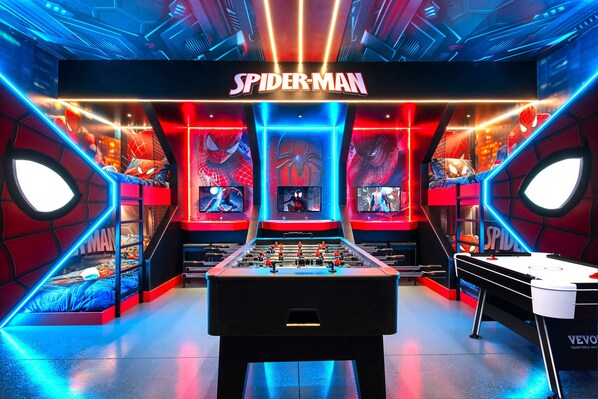Epic Spider-Man themed game room with beds, foosball, and arcade fun!
