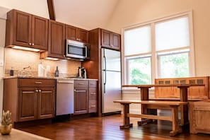 View of kitchenette with full-sized fridge, d/w, stove and dinette.