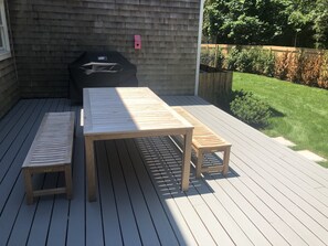 view of large Weber propane grill, deck and outdoor dining table