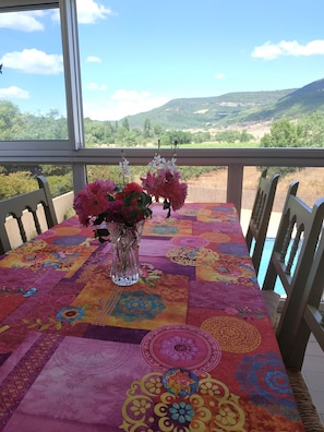 véranda avec vue sur piscine, vignes et collines