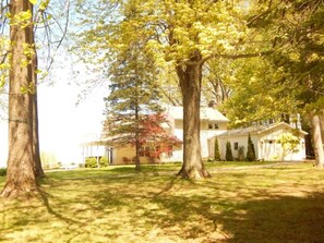 View of the house and large treed lot as you approach from the road. 