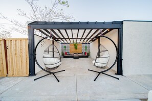 Swinging chairs and covered patio area.