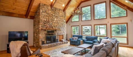 Huge great room with soaring wood ceilings and heavy timbers, stone wood burning fireplace and abundant seating