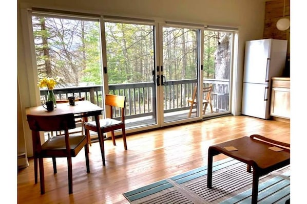 An expanse of sliding glass doors leads to the balcony, with mountain views.