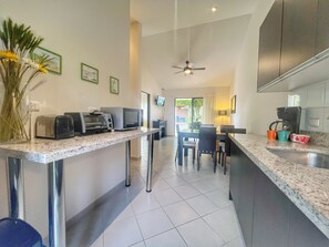 The galley kitchen has a ceramic cooktop and small appliances.