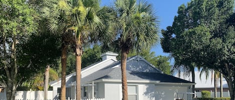 Your winter home complete with tall palm trees and a white picket fence