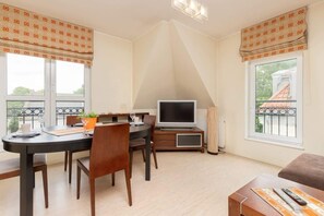 A bright living space with a dining table and chairs near a window, creating a welcoming ambiance.