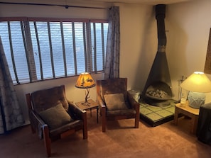 Sitting area next to fireplace. New curtains and wood shutters warmth & privacy