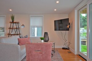 The living area with comfortable seating, TV, and water views.