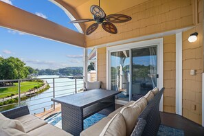 Deck with sectional seating, lake views and ceiling fan.