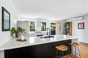 Spacious, Elegant and Pristine Kitchen with Sleek Countertops and Additional Seating