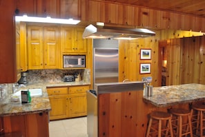 Kitchen area with stainless steel appliances, counter for additional seating