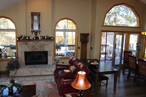 Living room, fireplace, open to dining, loft, kitchen, deck, lots of windows 