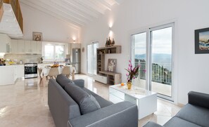 Living, Dining and Kitchen area with balcony that overlooks pool deck with views