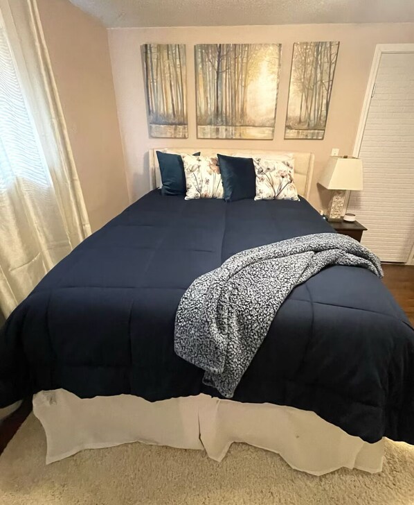 Bedroom Area. Includes queen bed, night stand, lamp.