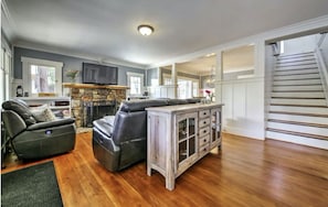 Living room with reclining seats and wood burning fireplace.