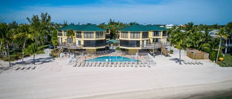 Aerial view looking out on the pool and beachfront on a typical tropical day.