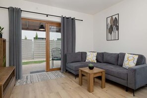 Cozy living room with a corner sofa bed, TV and access to the terrace/patio.