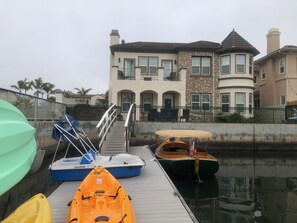 View of the house from the boat dock loaded with toys. Green boat separate.